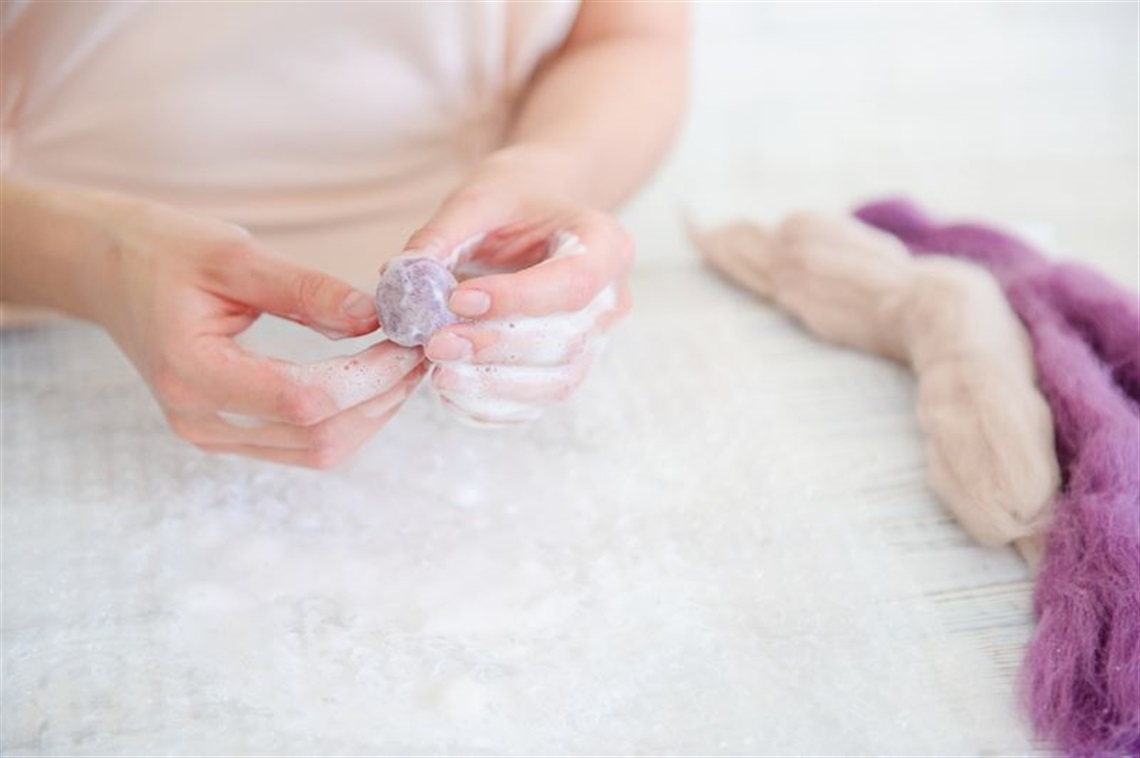 a_close_up_of_a_person's_hands_using_wool_felt