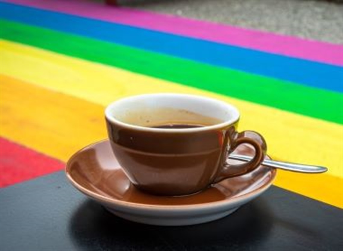 Coffee_cup_with_rainbow_background.jpg