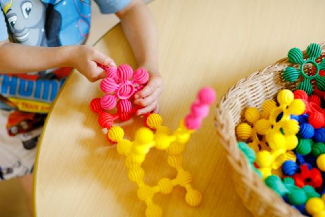 child_playing_with_colourful_plastic_building_blocks.jpg