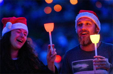 Two people singing while holding candles